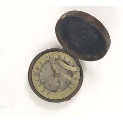 Pocket brass sundial with magnetic compass and hardwood case.